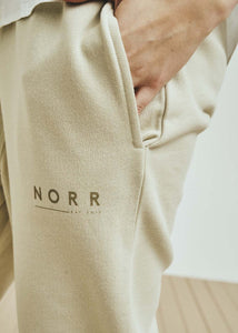 NORR Daisy sweat pants have a relaxed fit and tapered leg, with elastic in waist and hem. There is a subtle logo print on the front leg. Cotton